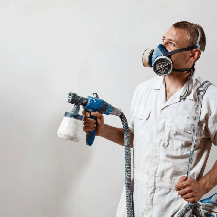 Worker Painting Wall with Spray Gun white color